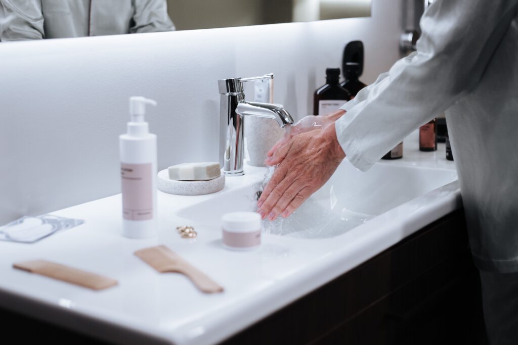 Inicio Close-up of a man washing hands in a modern bathroom, emphasizing hygiene and cleanliness.